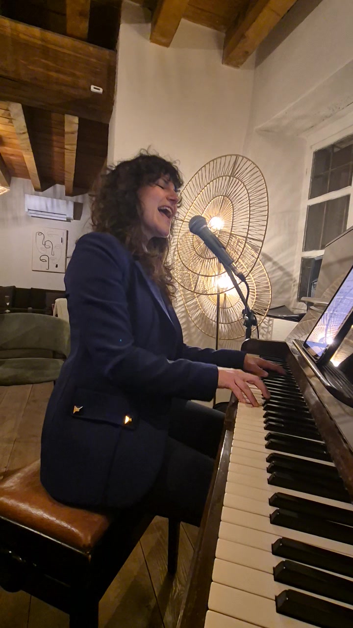 Nicole singing while playing the piano during a live music evening at Casa Ellie