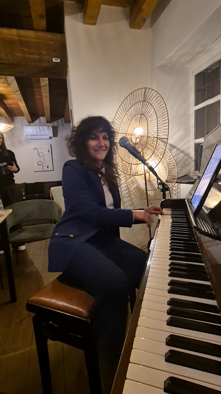 Nicole seated at Casa Ellie's piano performing for guests