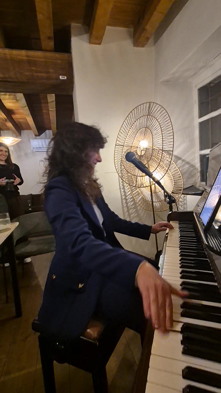 Nicole playing the piano keys during a live music evening