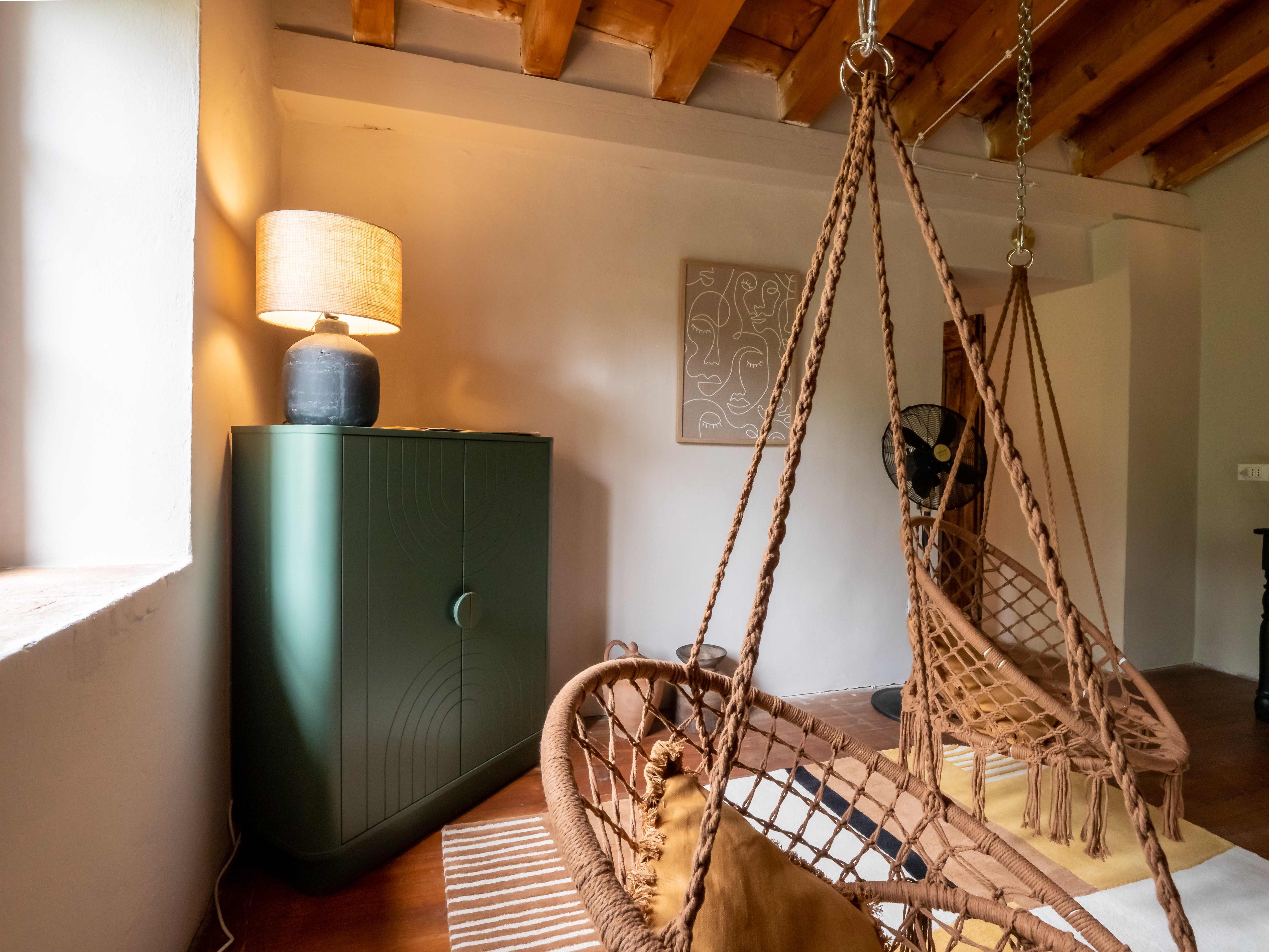 Sophisticated green cabinet with ceramic lamp and artwork