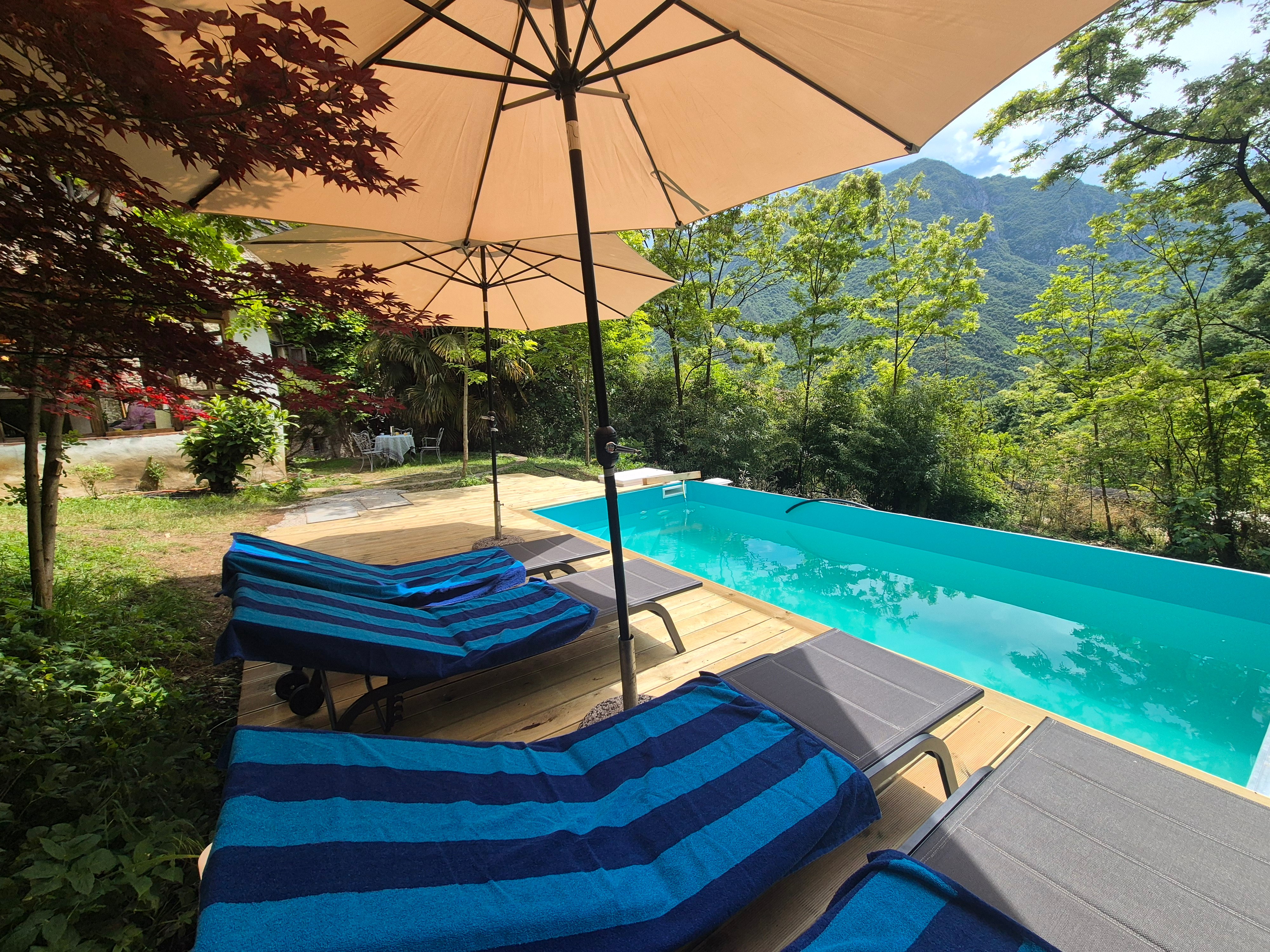 Poolside loungers under umbrellas with panoramic mountain views