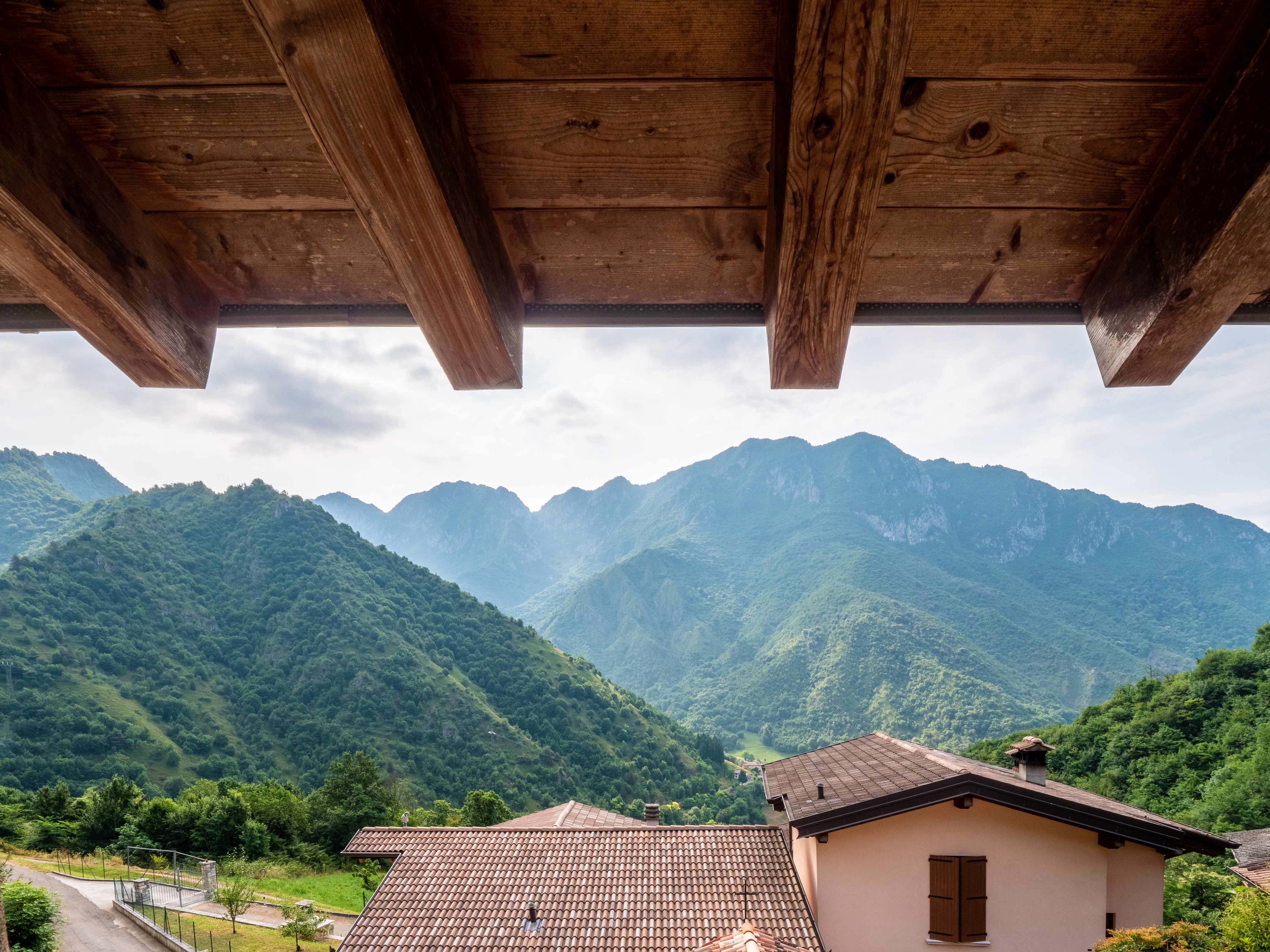 Breathtaking mountain views from covered terrace with wooden beams