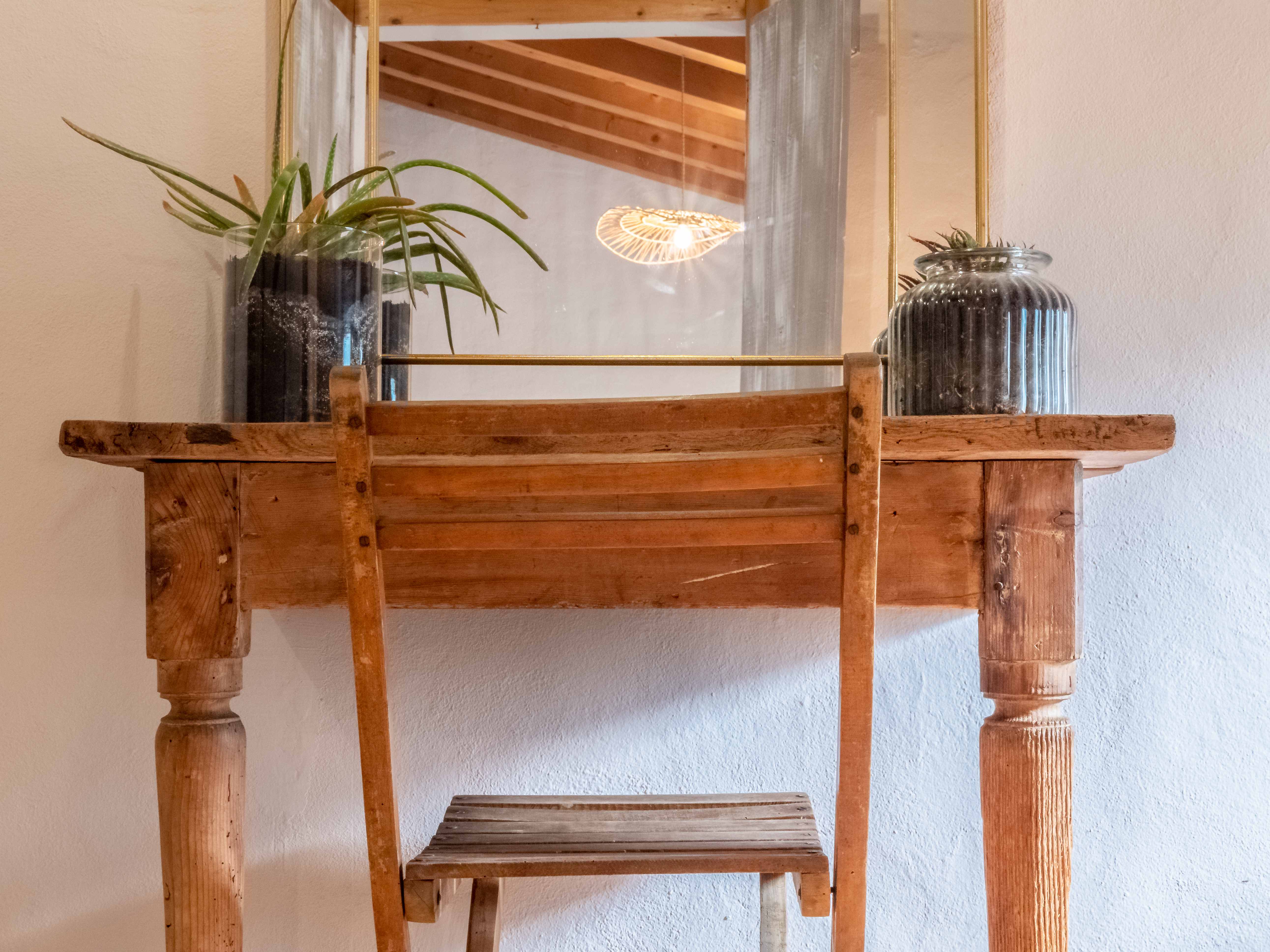 Rustic wooden vanity desk with arched mirror and ambient lighting