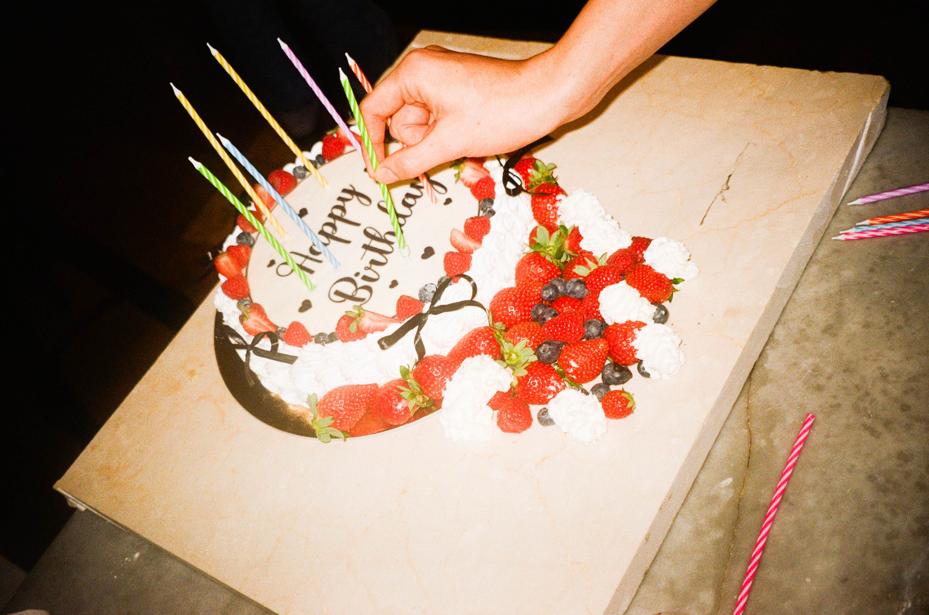 Birthday cake decorated with fresh berries and candles