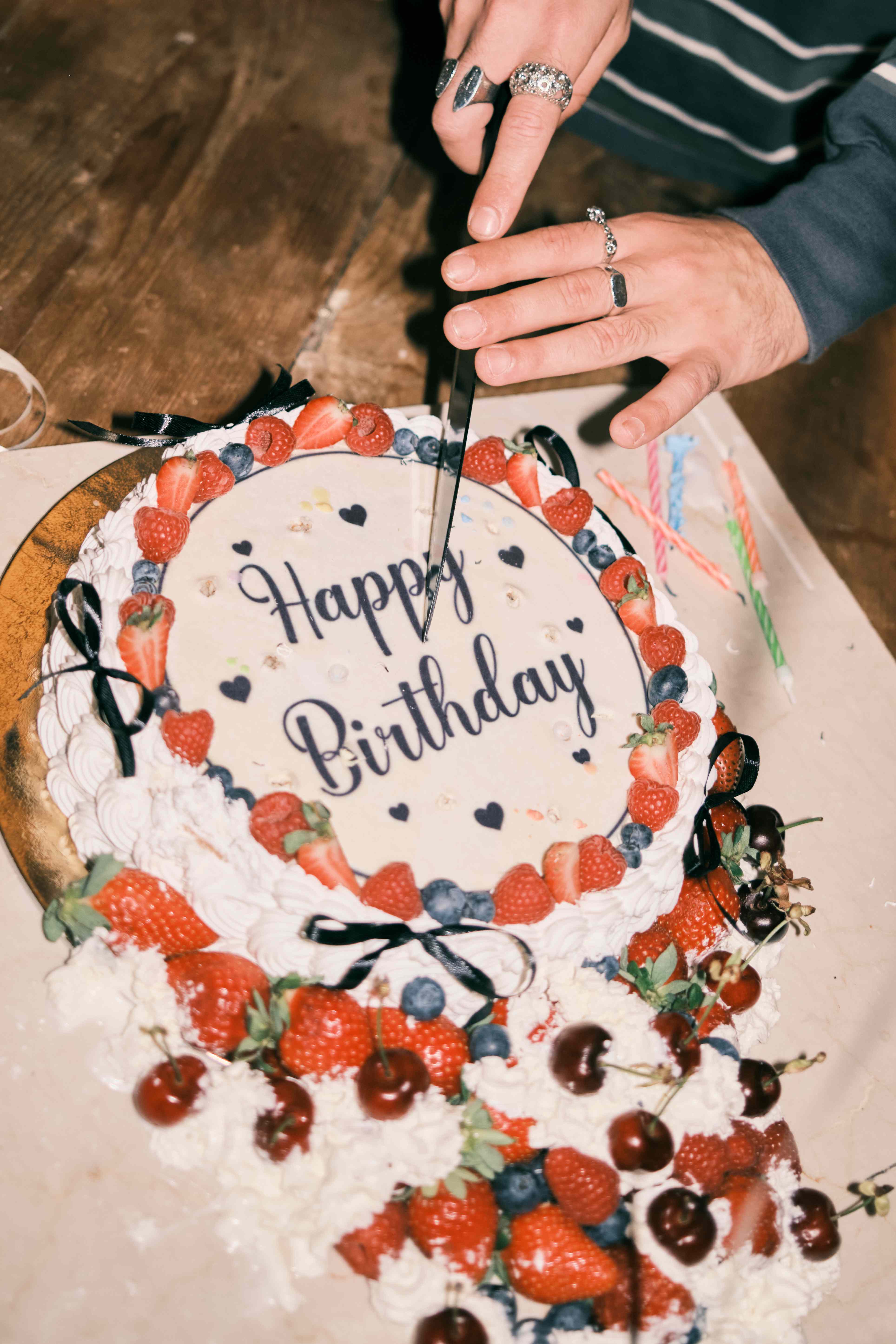 Cutting a fruit-topped birthday cake
